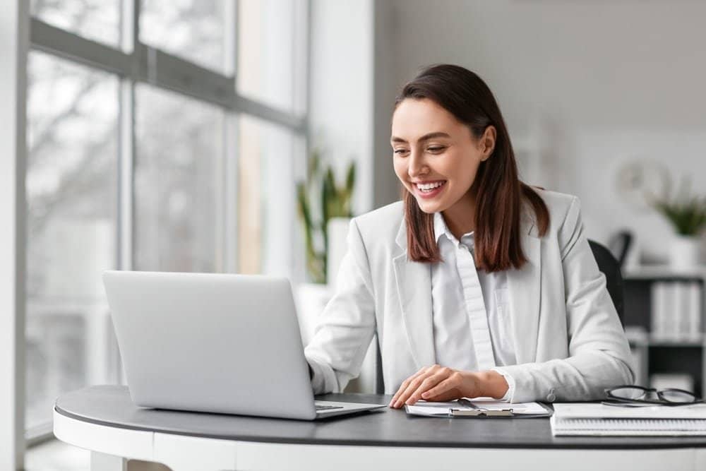 Pretty,Businesswoman,Working,With,Laptop,At,Table,In,Office