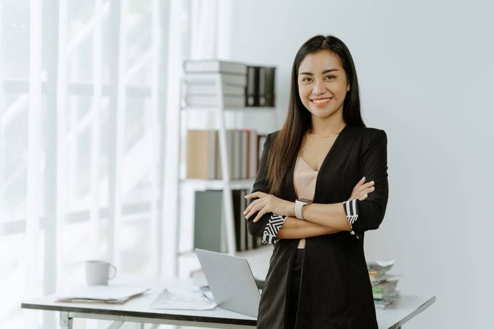 Asian,Woman,Sitting,At,A,Desk,Working,In,The,Office